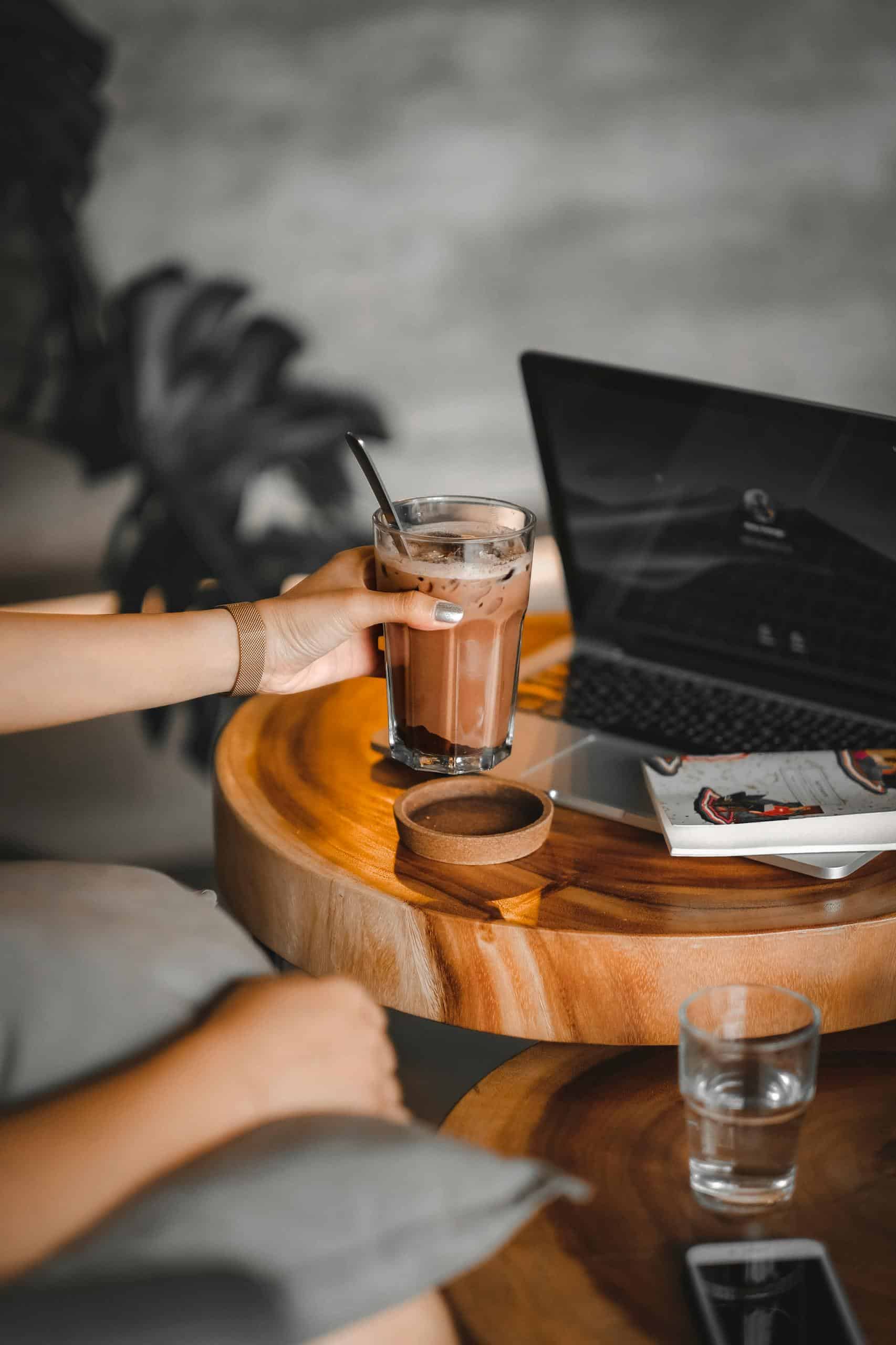 A cozy cafe setting featuring a latte, laptop, and a relaxing environment for work or leisure.